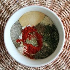 spices and seasonings in a white bowl on a woven place mat, top view