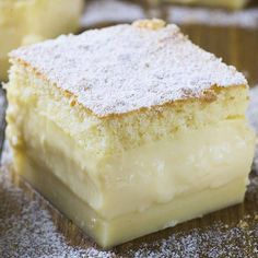 several pieces of cake sitting on top of a wooden table covered in powdered sugar