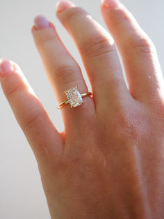 a woman's hand with a ring on it and a diamond in the middle