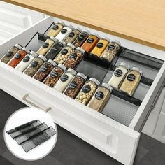 an open drawer with spices and seasonings in it on the floor next to a kitchen counter