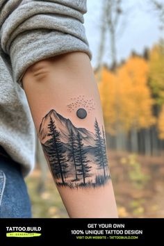 a person with a tattoo on their arm that has trees and mountains in the background