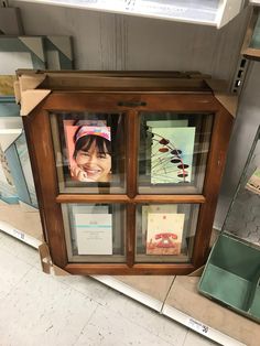 a display case filled with pictures and cards in a store's glass front window