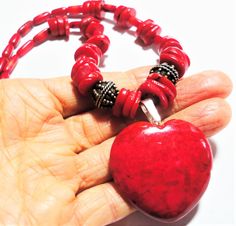 "Red heart pendant on red bamboo coral bead necklace, with sterling silver Bali beads, and sterling toggle closure. Bright true red riverstone heart pendant is the centerpiece on the bright red coral bead necklace. Two large solid sterling Bali beads are featured on each side of the pendant. The red heart pendant with sterling bail meaures 1 3/4\" from the top of the bail to the tip of the heart, and it is 1 3/8\" wide. The red coral necklace is 19\" long. Show someone you love that your heart r Traditional Red Heart-shaped Jewelry, Red Heart Pendant, Red Bamboo, Red Coral Necklace, Coral Beads Necklace, Bamboo Coral, Necklace Extender, Miramar Beach, Toggle Necklace