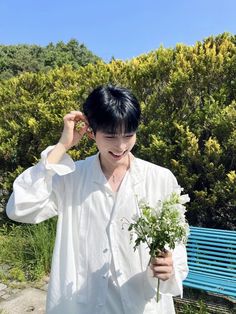 a young man is holding flowers in his hands