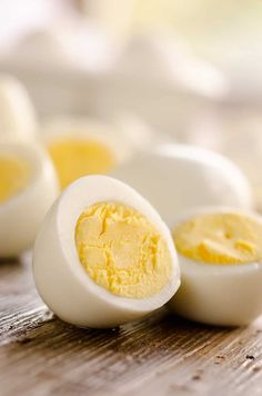 hard boiled eggs on a wooden table with one cut in half