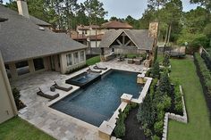 an aerial view of a backyard with a pool and hot tub in the foreground