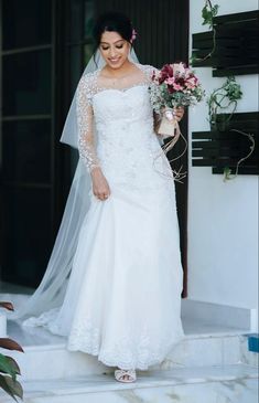 a woman in a wedding dress is walking down the steps