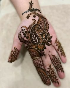 a woman's hand with henna tattoos on it