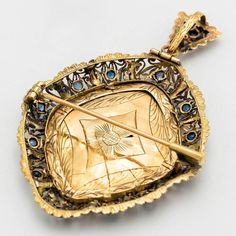 The article is entirely worked and hand -painted in gold and silver with sapphires in the outline. It can be used both as a pendant and as a brooch. Traditional Yellow Gold Collectible Brooch, Antique Blue Jewelry With Brooch, Baroque Yellow Gold Ceremonial Jewelry, Ornate Gold Locket Brooches, Formal Pendant Brooch With Intricate Design, Ornate Baroque Jewelry With Rose Cut Diamonds, Victorian Ceremonial Brooch, Victorian Large Pendant Jewelry For Weddings, Victorian Wedding Jewelry With Large Pendant