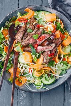 a salad with steak and vegetables in a bowl