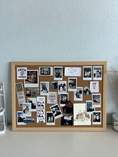 a cork board with pictures and magnets on it next to a vase filled with flowers