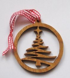 a wooden ornament with a christmas tree in the center on a red and white checkered ribbon