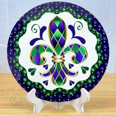 a blue and green plate with a gold fleur de lis design on it