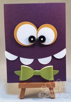 a close up of a purple card with eyes and a green bow tie on it