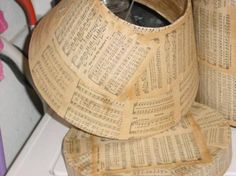 two vases made out of old book pages sitting on a counter top next to each other