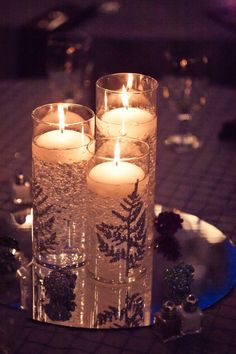 three lit candles are sitting on a table