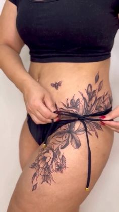 a woman is showing off her stomach with flowers on it