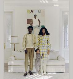 a man and woman standing next to each other in front of a white couch