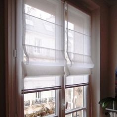 two windows with white blinds in a room