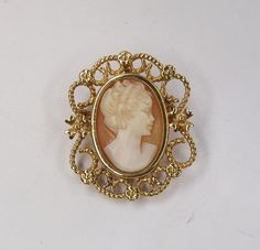 Marked as 14k (tested as 16k) gold. 5.95 grams total weight The main body measures 30.8 x 26.3mm (not including the swing bale length) A 13 x 20mm real shell carved cameo center piece. Bezel set, secure, no damages, repairs or cracks. Pin and attached swing bale are functioning perfectly. A well kept piece from an estate. All inquiries answered. More photos possible as requested. Tracked and Insured Shipping included with the purchase. Thank you for your interest Link to my home page; https://www.etsy.com/shop/DanPickedMinerals Hallmarked 14k Gold Brooch For Formal Occasions, Formal Hallmarked 14k Gold Brooches, Formal Engraved Yellow Gold Brooches, Formal Yellow Gold Engraved Brooches, Gold Filigree Brooches For Collectors, Gold Filigree Brooches Collectible, Collectible Gold Filigree Brooches, Collectible 14k Gold Hallmarked Brooch, Ornate Yellow Gold Brooch For Formal Occasions