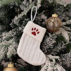 an ornament hanging from a christmas tree with a dog's paw on it