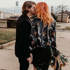 a man and woman kissing on the street