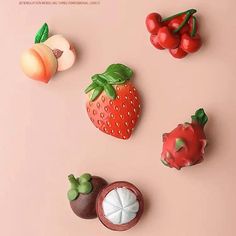 there are many different fruits and vegetables on this pink surface, including strawberries, peaches, cherries, and more