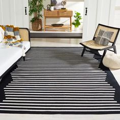 a black and white striped rug in a living room with two wicker chairs on the floor