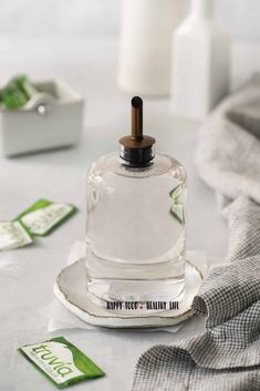 a bottle of perfume sitting on top of a table next to napkins and cups