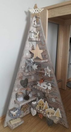 a christmas tree made out of wooden boards and other decorations on top of a hard wood floor