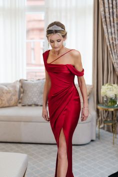 a woman in a red dress walking through a living room