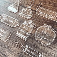 clear acrylic name tags and necklaces on a wooden table with an apple