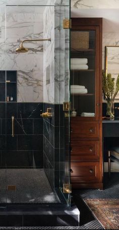 a bathroom with black and white marble walls, gold trimmings and brass fixtures