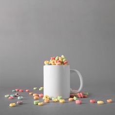 a white coffee mug filled with cereal sprinkles