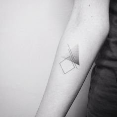 a black and white photo of a person's arm with a geometric tattoo on it