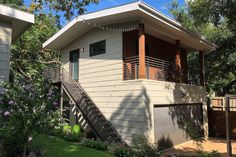 a small house with a balcony on the second floor and stairs leading up to it