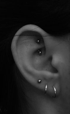 a woman's ear with two piercings on it