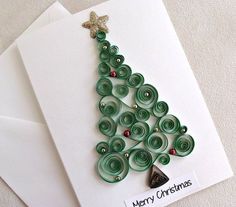 a christmas card with a green tree made out of rolled up paper on top of white envelopes