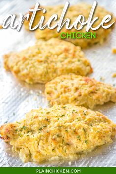 three chicken patties on a baking sheet with the words artichoke chicken written above them