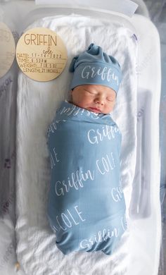 a newborn baby wrapped in a blue blanket with the words griffen written on it