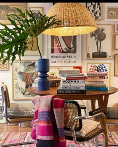 a living room filled with furniture and lots of books on top of a wooden table