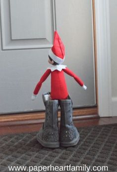 an elf is standing on top of a pair of boots in front of a door