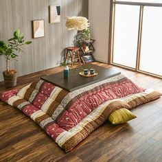 a living room filled with furniture and wooden flooring next to a large open window