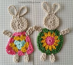 two crocheted bunnies sitting next to each other on top of a table