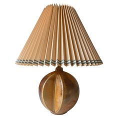 a lamp that is sitting on top of a wooden table cloth shade with a white background