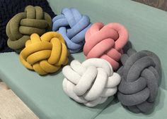 four different colored knots sitting on top of a blue couch next to a black beanie