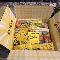 a box filled with lots of food sitting on top of a floor next to a wall