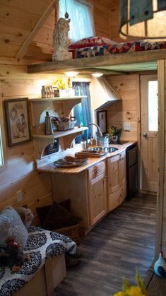 the interior of a tiny cabin with wood flooring and wooden walls, including a loft bed