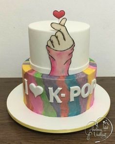 a cake decorated with the words i love k - pop and a hand holding a heart