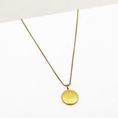 Lorna Locket Necklace | Simple Gold Photo Locket | Larissa Loden Gold Locket Necklace With Round Pendant For Everyday, Gold Round Pendant Locket Necklace For Everyday, Brass Box Chain Necklace With Round Pendant, Brass Medallion Charm Necklaces, Everyday Medallion Necklace With Adjustable Chain, Adjustable Medallion Necklace, Adjustable Round Pendant Locket Charm Necklace, Minimalist Gold Locket Necklace, Brass Medallion Locket Necklace With Adjustable Chain